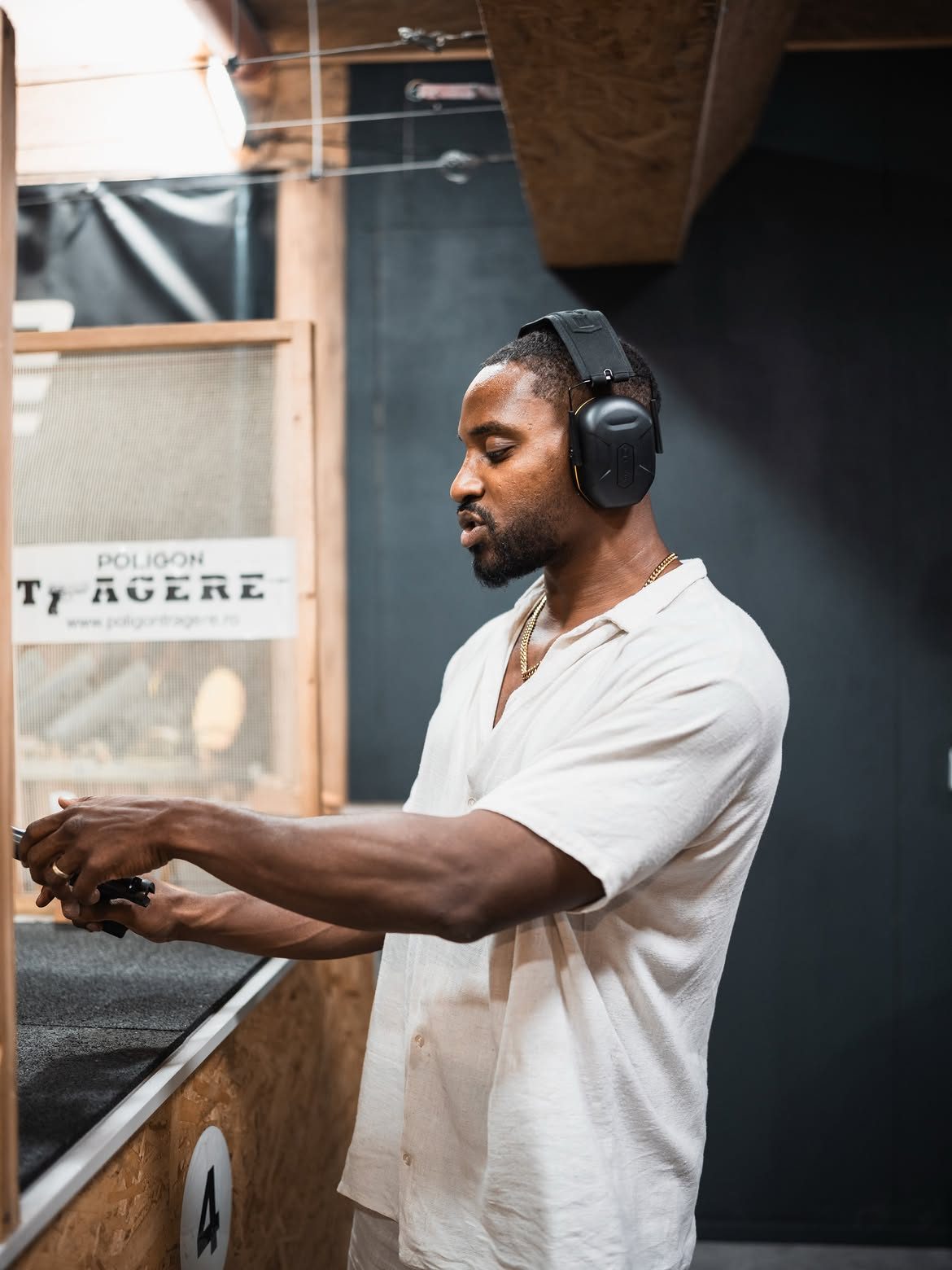 Martel in ear protection loading a magazine at an indoor shooting range